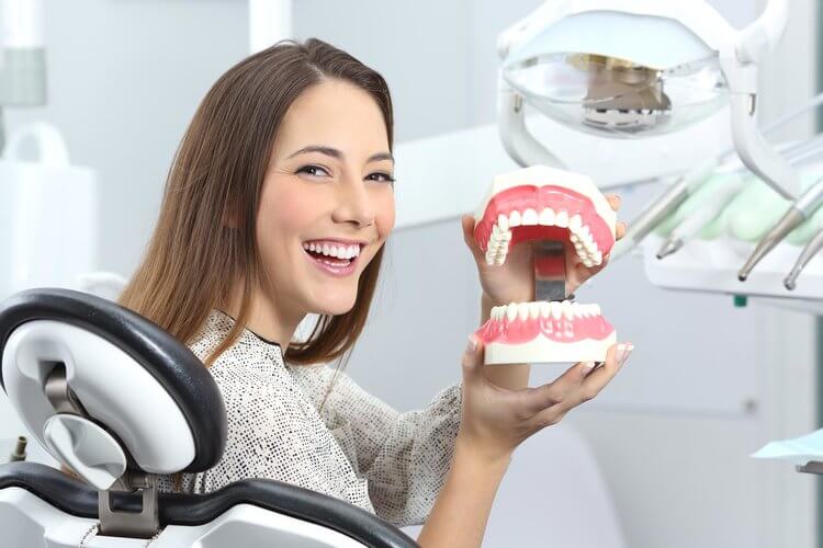 Morgan Street Dental Centre Gum Disease Family Dentistry- Woman with Beautiful Smile Showing Model Teeth 